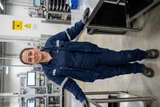Femme en uniforme de travail et chaussures de sécurité dans une usine