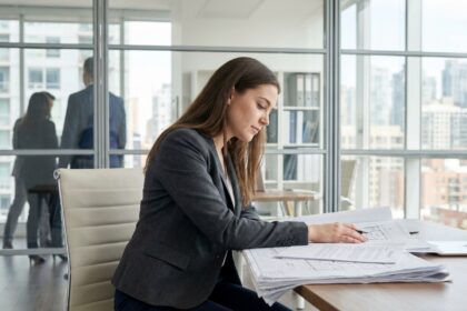 Jeune femme professionnelle examinant des documents immobiliers